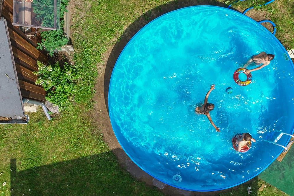 Kinder planschen in einem Garten im Pool: Im Planschbecken befinden sich oft auch Bakterien.