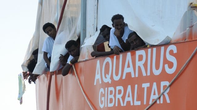 Aus Seenot gerettete Migranten blicken im Juni 2017 von der "Aquarius" herunter. Aus Seenot gerettete Migranten blicken im Juni 2017 von der "Aquarius" herunter.