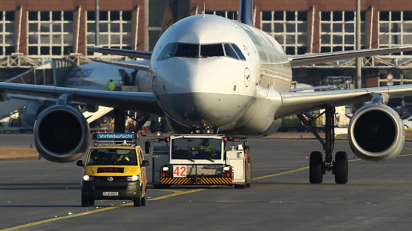 Ein Lufthansa Airbus mit einem Schleppfahrzeug auf dem Flughafen Frankfurt: Bei einem Brand wurde eine Lufthansa-Maschine schwer beschädigt, sechs Menschen wurden verletzt (Symbolbild).