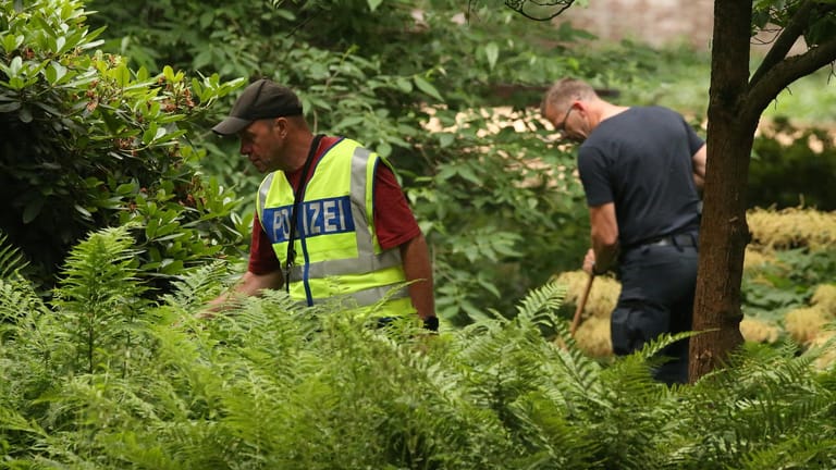 Der Tatort in Viersen: Polizisten durchsuchen ein Gebüsch.