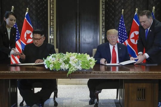 US-Präsident Donald Trump (r) und der Machthaber von Nordkorea Kim Jong Un unterzeichnen eine gemeinsame Vereinbarung.