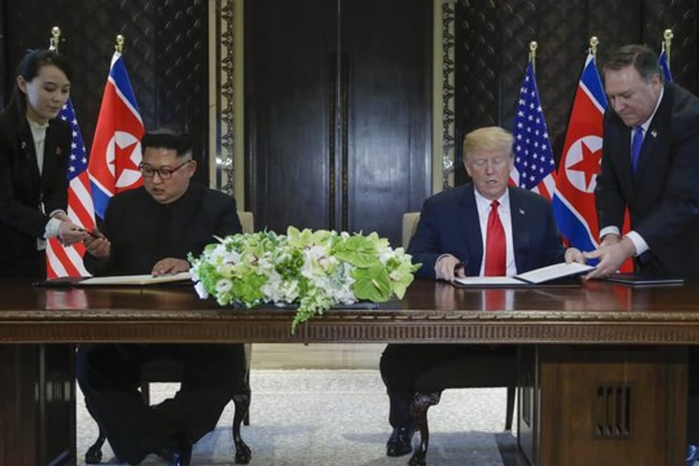 US-Präsident Donald Trump (r) und der Machthaber von Nordkorea Kim Jong Un unterzeichnen eine gemeinsame Vereinbarung.