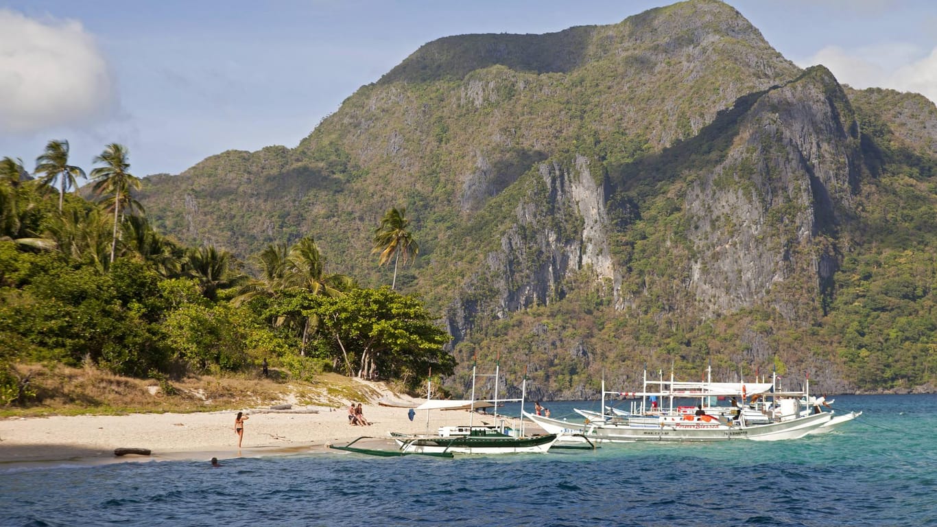 Für viele Touristen die Schönste: Boote am Sandstrand von Helicopter Island auf der philippinischen Insel Palawan.