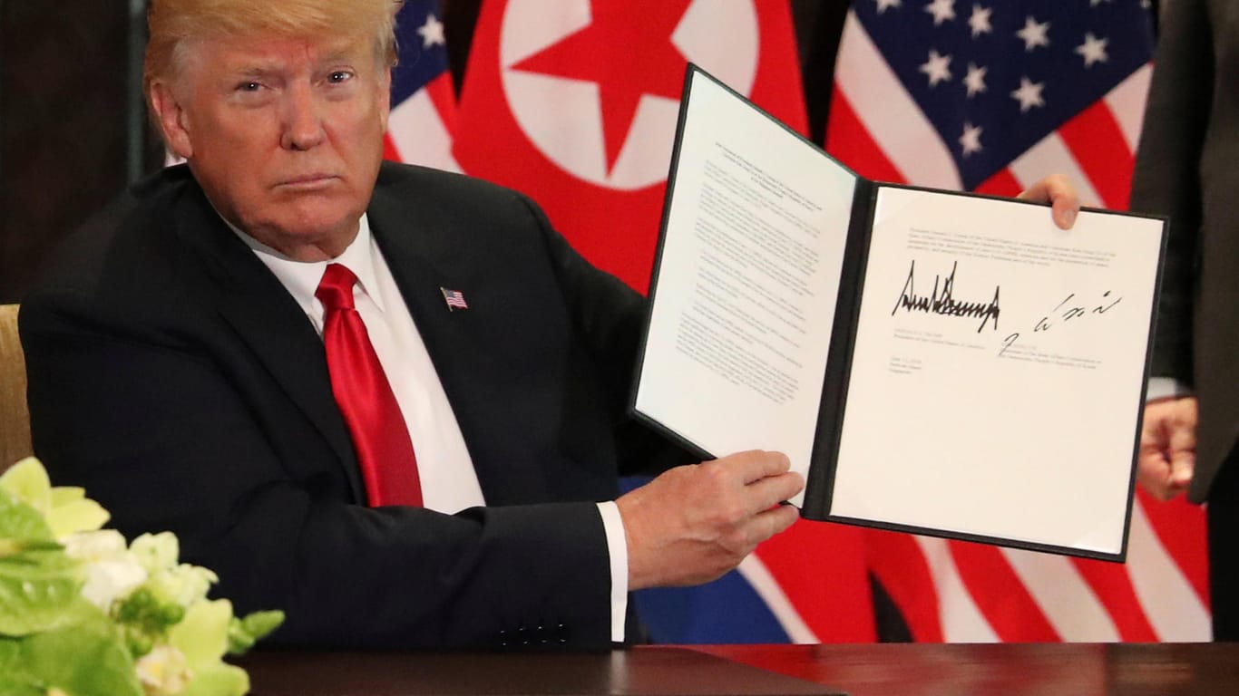 Donald Trump zeigt die Erklärung vor, die er gemeinsam mit Kim Jong Un in Singapur unterschrieben hat.