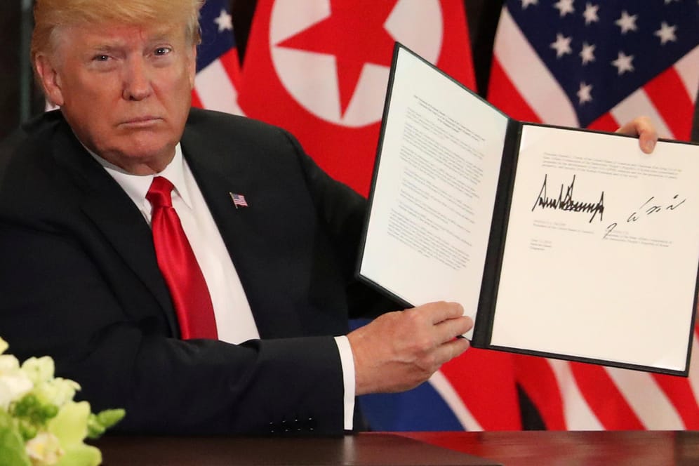 Donald Trump zeigt die Erklärung vor, die er gemeinsam mit Kim Jong Un in Singapur unterschrieben hat.