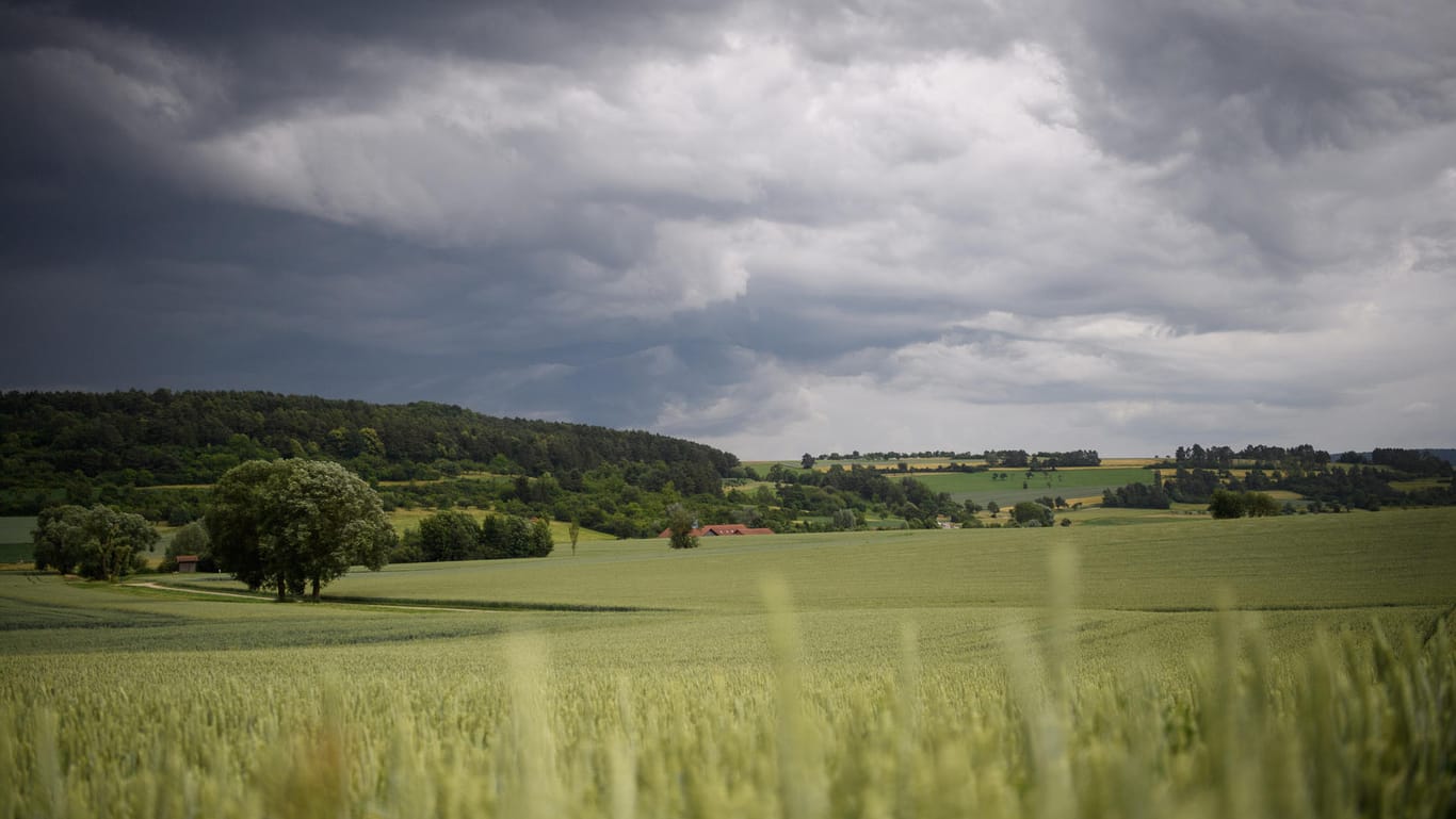 Dunkle Wolken über Feldern in Friolzheim (Baden-Württemberg): Ab Donnerstag soll ein Tief etwas Regen und kühlere Temperaturen bringen.