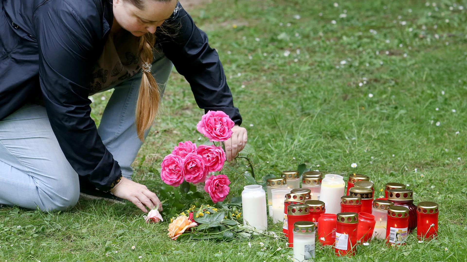 Eine Frau legt in der Nähe des Tatorts Blumen nieder: Im Fall der tödlichen Messerattacke auf eine 15-Jährige in Viersen hat sich ein 17-Jähriger der Polizei gestellt.