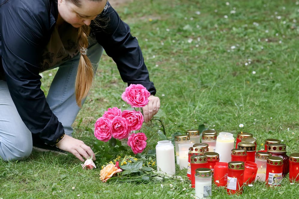 Eine Frau legt in der Nähe des Tatorts Blumen nieder: Im Fall der tödlichen Messerattacke auf eine 15-Jährige in Viersen hat sich ein 17-Jähriger der Polizei gestellt.