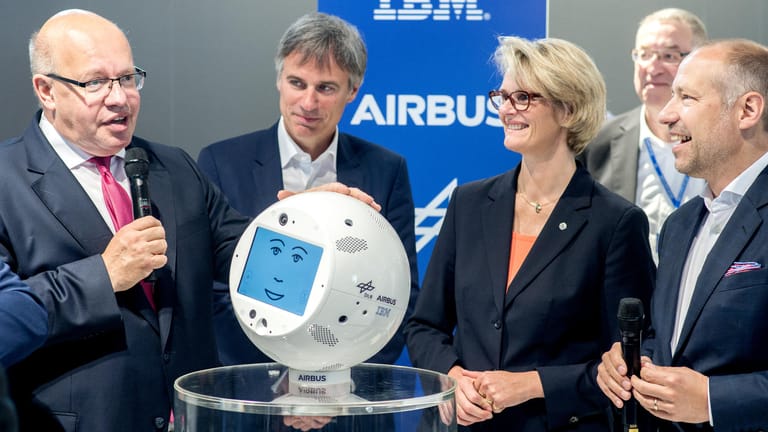 Peter Altmaier (l, CDU) sieht sich am Stand von IBM bei der Cebit den Weltraum-Roboter CIMON an.