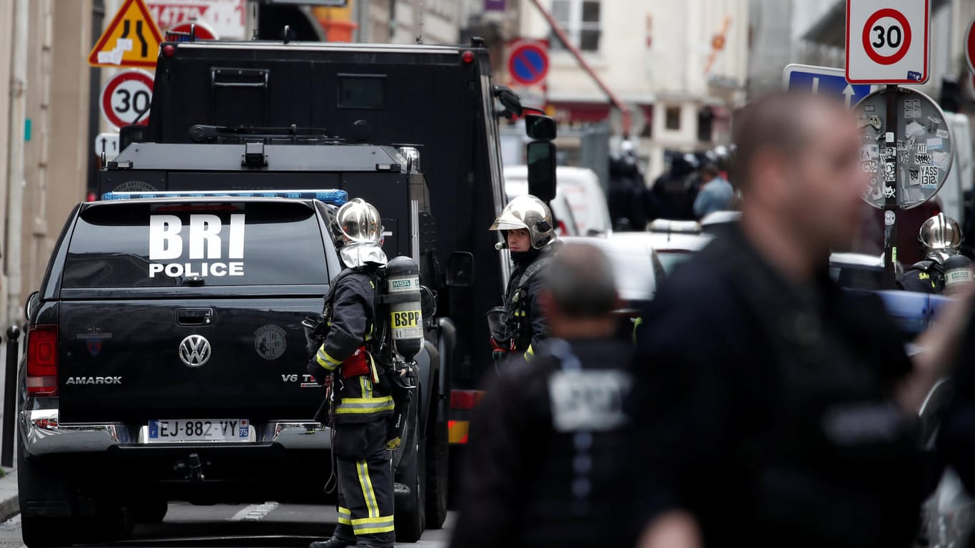 Polizisten, Spezialkräfte und die Feuerwehr sichern eine Straße in Paris: In der französischen Hauptstadt ist es zu einer Geiselnahme gekommen.