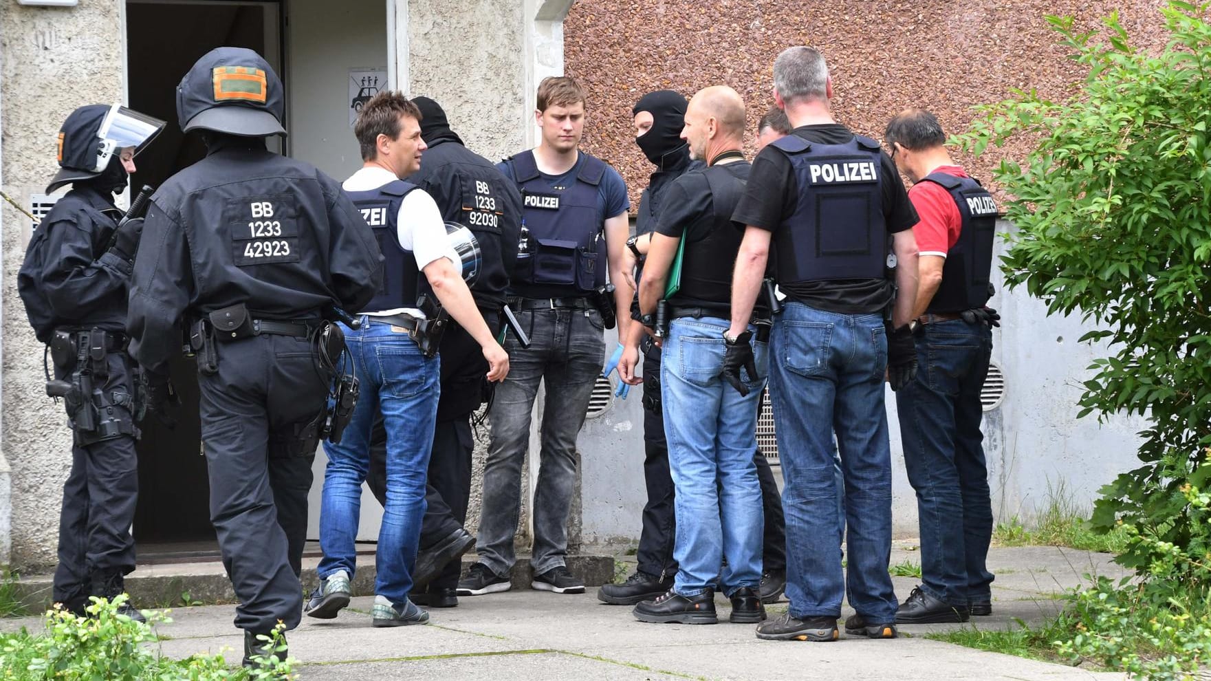 Polizisten stehen vor dem Asylbewerberheim in Cottbus: Bei der Durchsuchung fand die Polizei Schlagwerkzeuge. Polizisten stehen vor dem Asylbewerberheim in Cottbus: Bei der Durchsuchung fand die Polizei Schlagwerkzeuge.