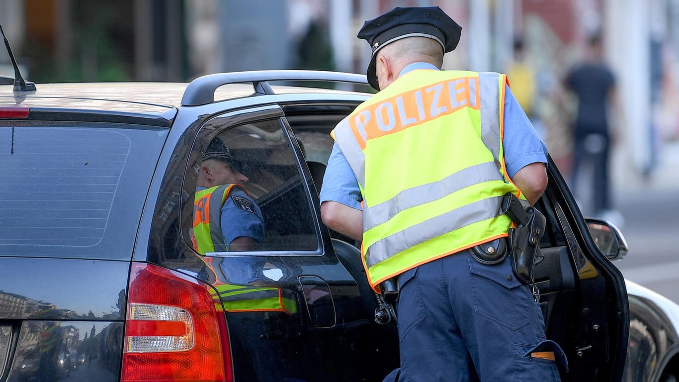 Ein Polizist hält bei einer Verkehrskontrolle ein Auto an: Bundespolizei entdeckt knapp 715.000 Euro in Wagen auf der Autobahn.