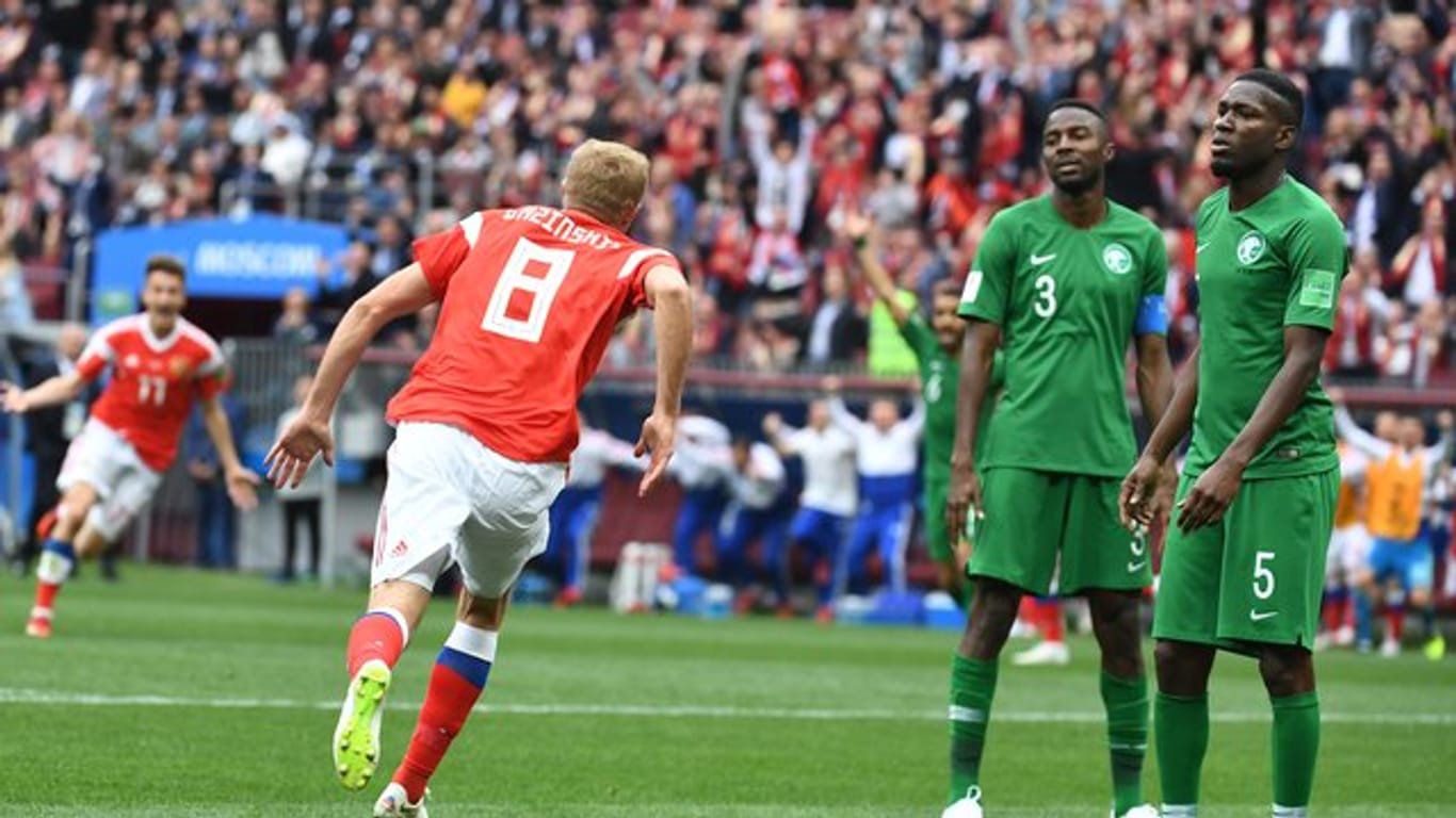 Russlands Torschütze Juri Gasinski (l) bejubelt das erste Tor der WM in Russland.
