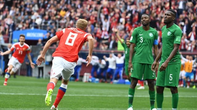 Russlands Torschütze Juri Gasinski (l) bejubelt das erste Tor der WM in Russland.