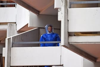 Ein BKA-Beamter in Schutzkleidung im betroffenen Wohnkomplex in Köln-Chorweiler.