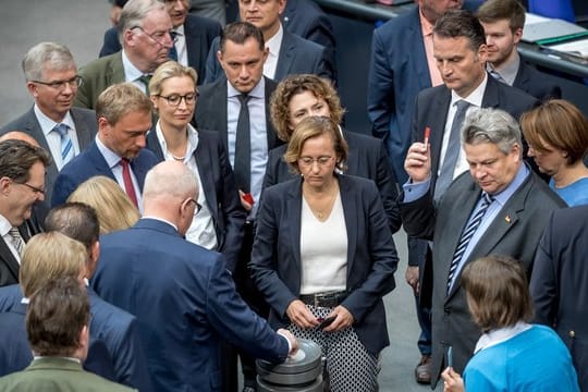 Bundestagsabgeordnete werfen im Plenum im Bundestag ihre Stimmkarten zur Abstimmung über die Parteienfinanzierung ein.