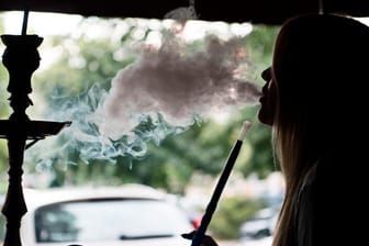 Eine junge Frau raucht in einer Shisha-Bar Tabak in einer Shisha-Pfeife: 30-Jähriger in Jenaer Shisha-Bar offenbar durch Kohlenmonoxid gestorben.