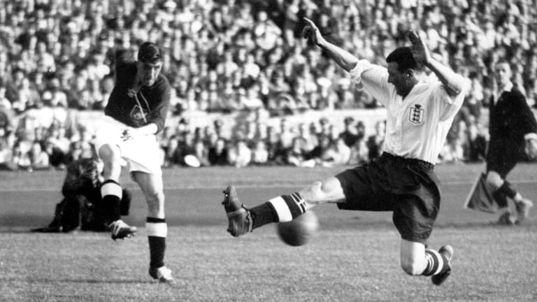 Der englische Verteidiger Hapgood (rechts) springt in einen Schuss des deutschen Rechtsaußen Ernst Lehner, aufgenommen beim Fußball-Länderspiel Deutschland gegen England (3:6) am 14.05.1938 im Berliner Olympiastadion.
