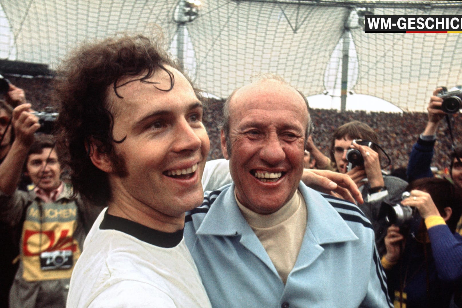 Überglücklich jubelnd liegen sich Franz Beckenbauer (links) und Trainer Helmut Schön nach dem 2:1-Sieg über die Niederlande im Endspiel der Fußball-Weltmeisterschaft am 07.07.1974 im Münchner Olympiastadion in den Armen.