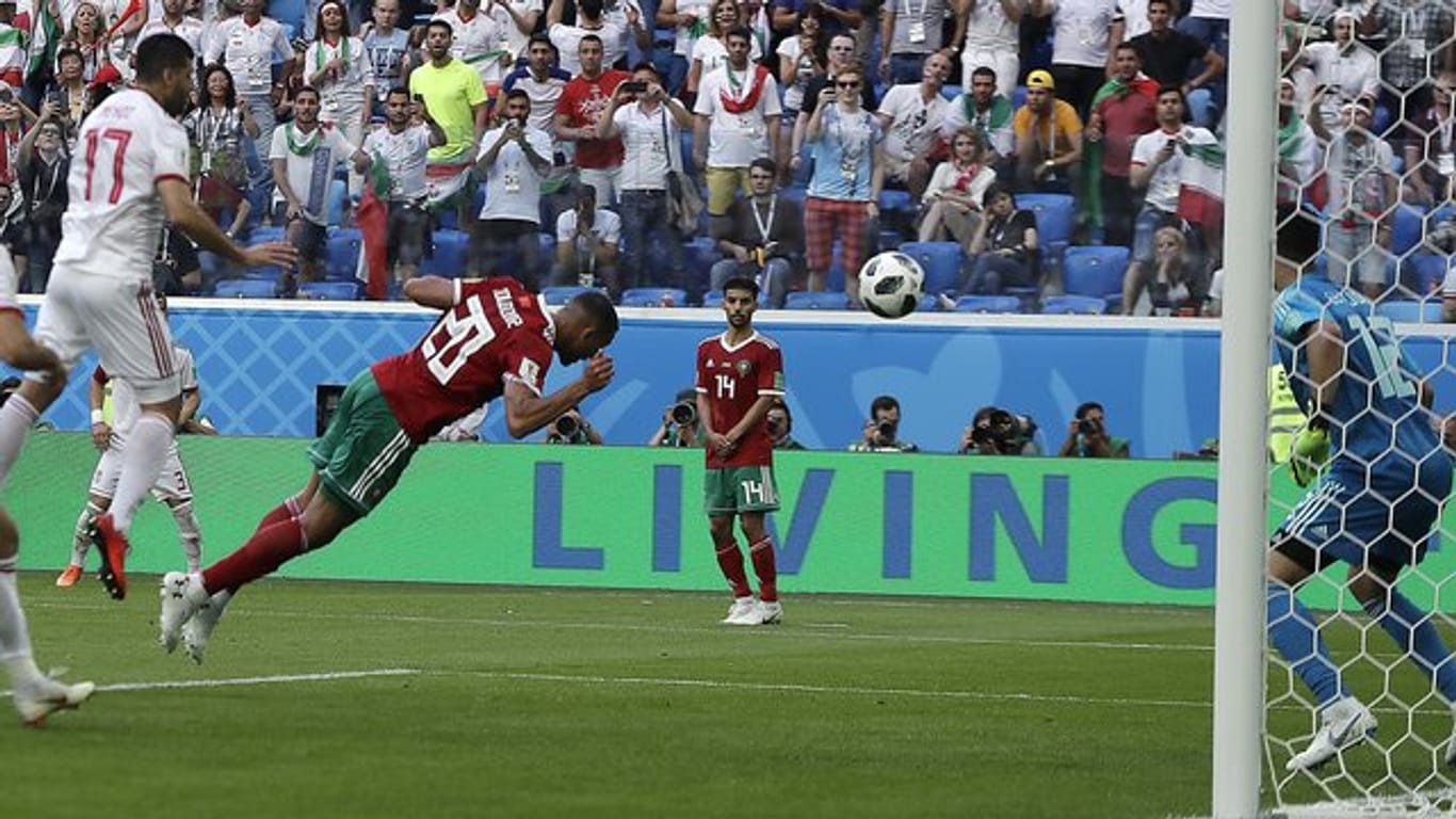 Marokkos Aziz Bouhaddouz (M) erzielt das Eigentor gegen seinen Torwart Munir (r), ds zum 1:0-Sieg der Iraner führt.
