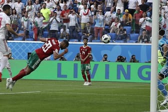 Marokkos Aziz Bouhaddouz (M) erzielt das Eigentor gegen seinen Torwart Munir (r), ds zum 1:0-Sieg der Iraner führt.