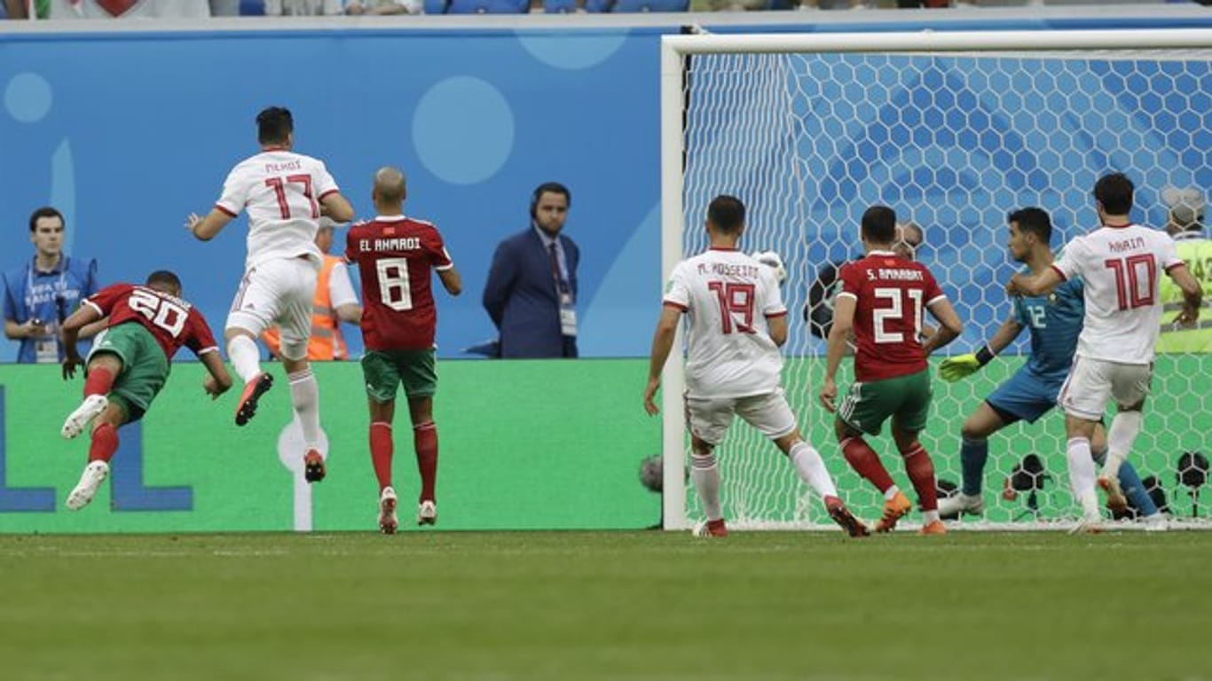 Marokkos Aziz Bouhaddouz (l/20) erzielt das Eigentor zum 0:1 im Spiel gegen Iran.