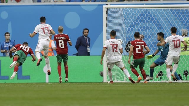 Marokkos Aziz Bouhaddouz (l/20) erzielt das Eigentor zum 0:1 im Spiel gegen Iran. Marokkos Aziz Bouhaddouz (l/20) erzielt das Eigentor zum 0:1 im Spiel gegen Iran.