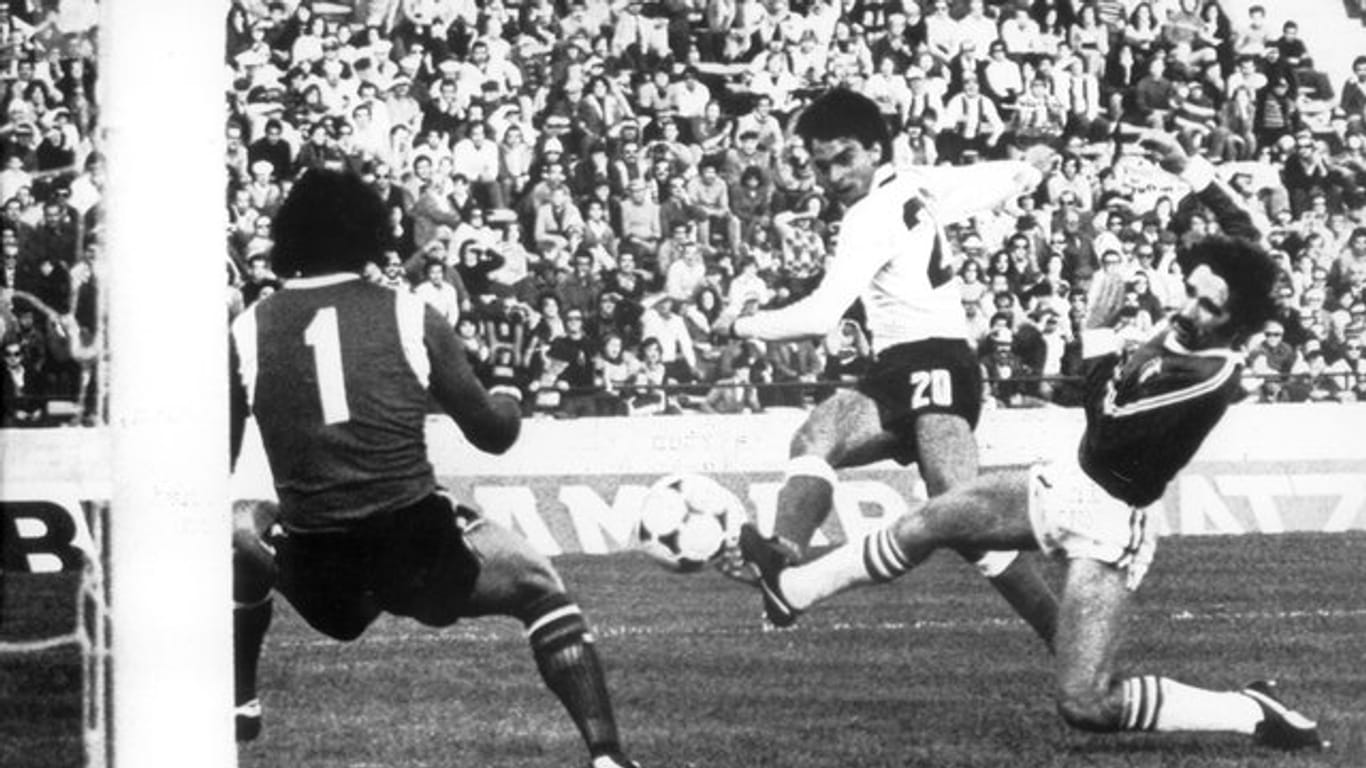 WM 1978 in Argentinien: Hansi Müller (M) erzielt trotz Bedrängnis durch den mexikanischen Abwehrspieler Leonardo Cuellar (r) die 2:0-Führung, lässt dabei Torhüter Jose Pilar Reyes (l) keine Abwehrchance.