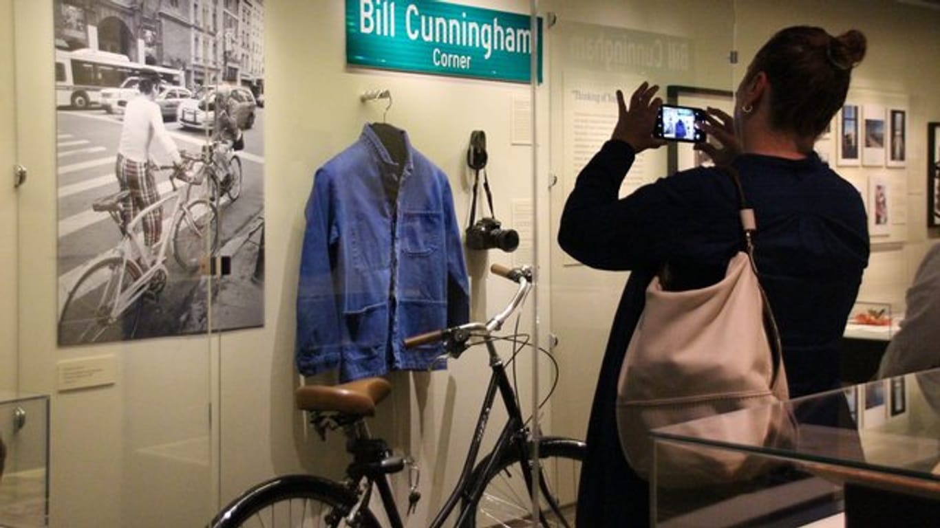 In der Ausstellung über den verstorbenen Fotografen Bill Cunningham ist auch seine tägliche Ausstattung zu sehen - ein Fahrrad, eine blaue Jacke und eine Kamera.