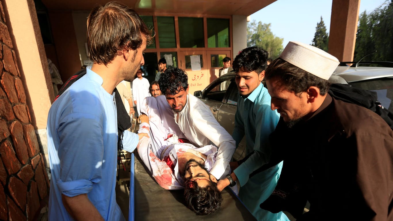 Verwandte tragen einen schwer verletzten Angehörigen ins Krankenhaus: 26 Menschen verunglückten nach einer detonierten Autobombe in Afghanistan.