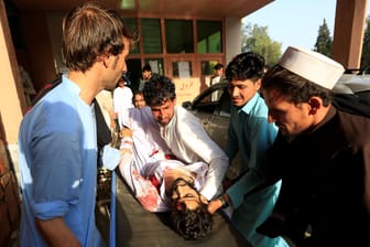 Verwandte tragen einen schwer verletzten Angehörigen ins Krankenhaus: 26 Menschen verunglückten nach einer detonierten Autobombe in Afghanistan.