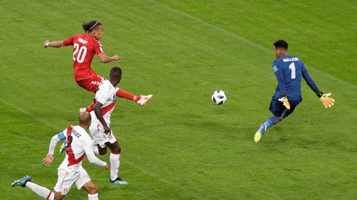Dänemarks Yussuf Yurary Poulsen (hinten links) erzielt gegen Perus Torhüter Pedro Gallese (r) den Treffer zum 1:0-Sieg.