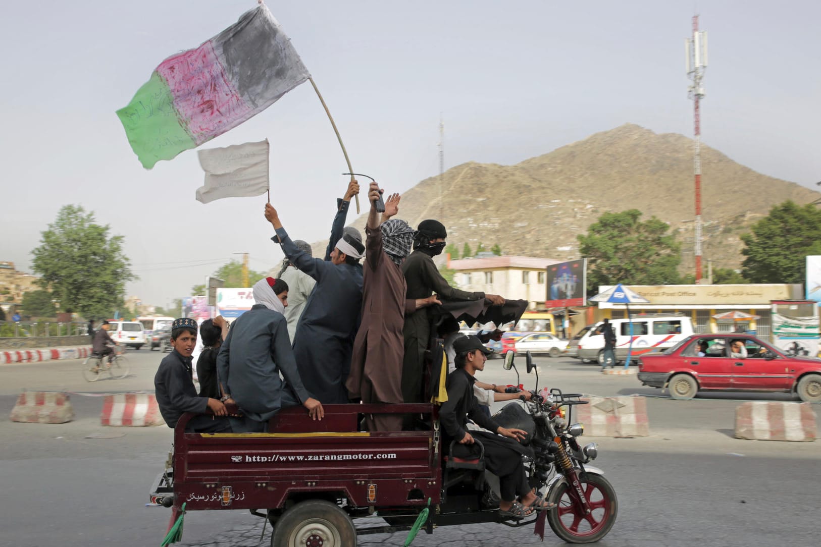 Kämpfe in Afghanistan: Talibankämpfer und ihre Anhänger tragen eine Darstellung der afghanischen Nationalflagge.