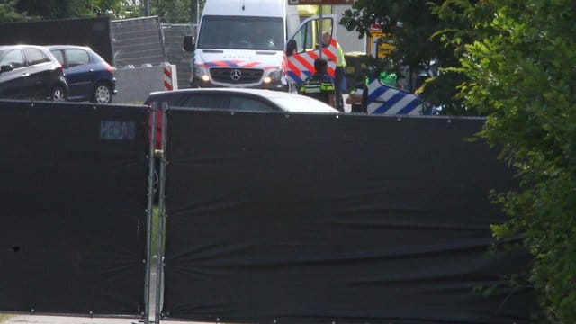 Rettungsfahrzeuge sind hinter Sichtschutz-Planen zu sehen. Rettungsfahrzeuge sind hinter Sichtschutz-Planen zu sehen.