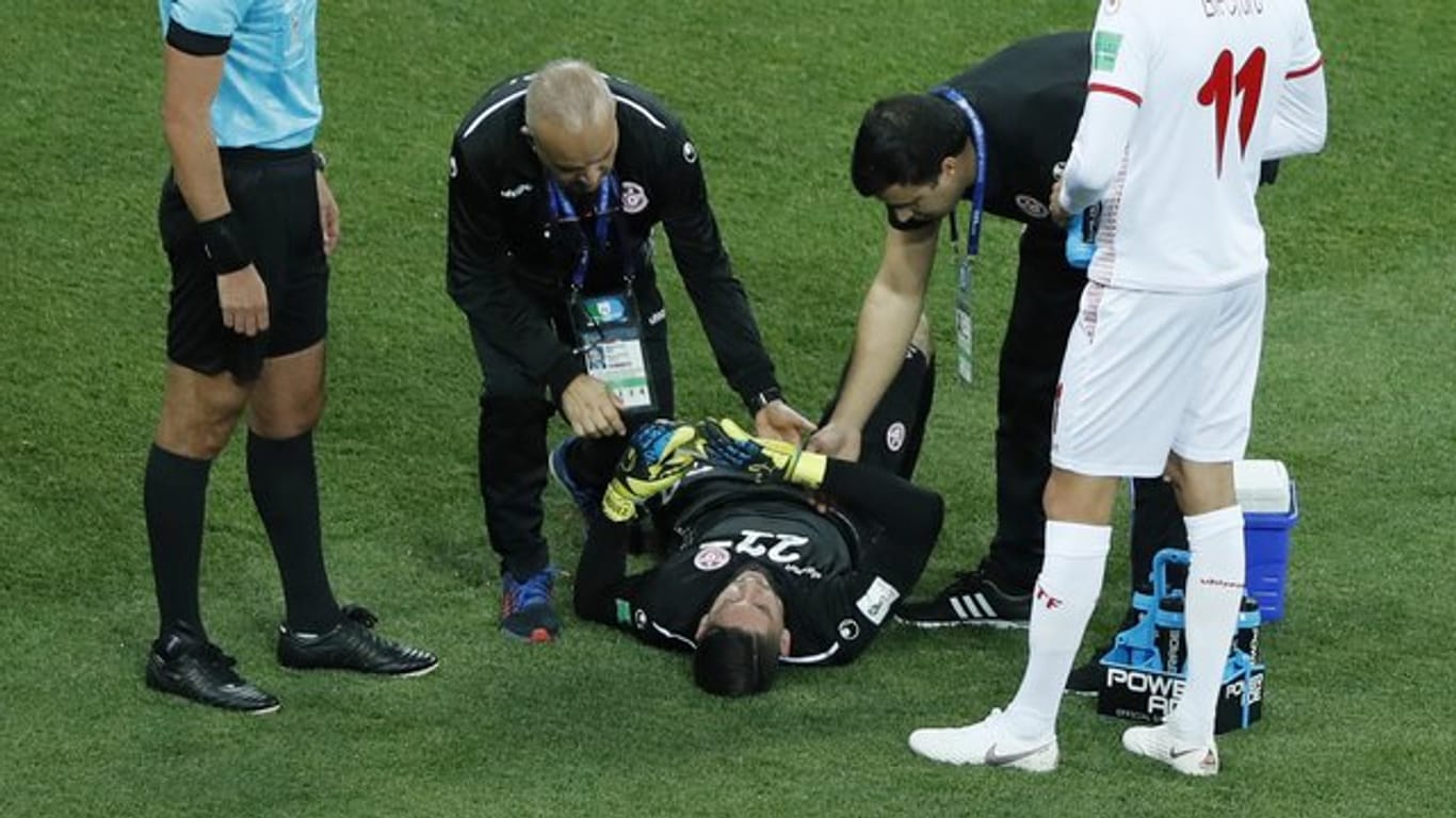 Tunesiens Torwart Mouez Hassen (M) liegt verletzt auf dem Platz und musste früh ausgewechselt werden.