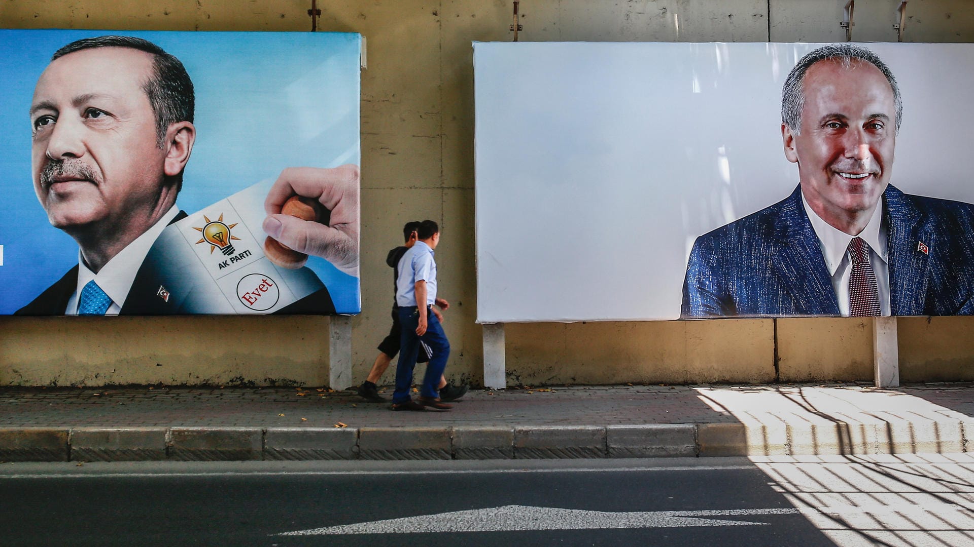 Menschen gehen an zwei Wahlplakaten von Recep Tayyip Erdogan (AKP, l) und Muharrem Ince (CHP) vorbei: In der Türkei finden am 24.06. Parlaments- und Präsidentschaftswahlen statt.