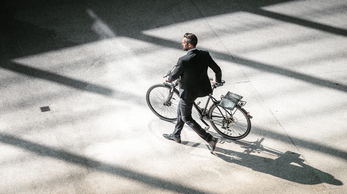 Geschäftsmann mit Fahrrad: Der Diebstahl eines Fahrrads ist über die Hausratversicherung abgedeckt – doch nicht in jedem Fall.