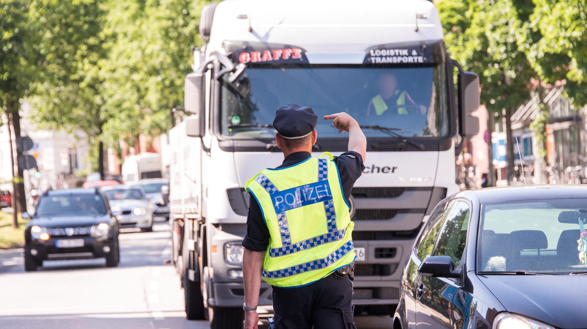 Ein Polizist hält einen Lastwagenfahrer für eine Kontrolle an: Wegen zu schmutziger Luft gilt in Hamburg auf einigen Straßen im Stadtteil Altona ein Fahrverbot für Fahrzeuge mit Diesel-Motoren bis zur Abgasnorm Euro5. Ein Polizist hält einen Lastwagenfahrer für eine Kontrolle an: Wegen zu schmutziger Luft gilt in Hamburg auf einigen Straßen im Stadtteil Altona ein Fahrverbot für Fahrzeuge mit Diesel-Motoren bis zur Abgasnorm Euro5.