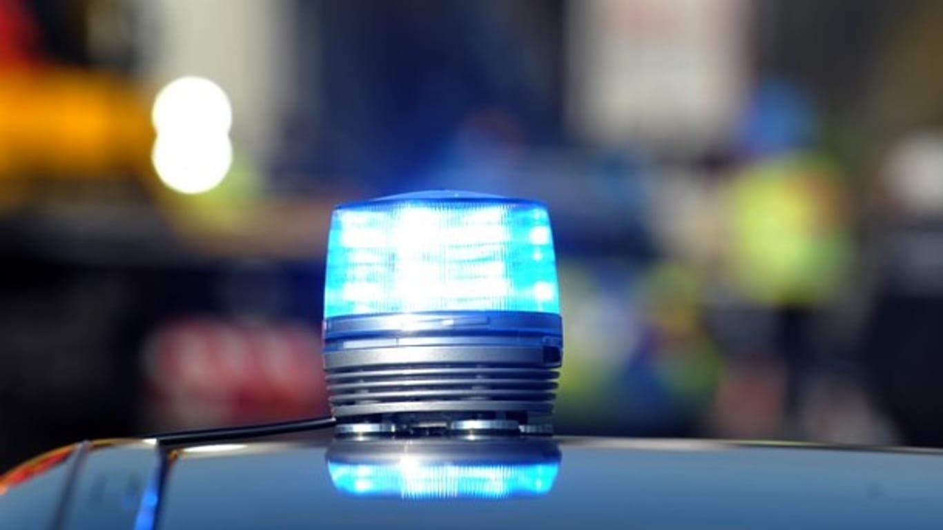 Das Blaulicht eines Streifenwagens leuchtet: Ein Passant hat in einem Gebüsch in Südhessen einen toten Mann gefunden.