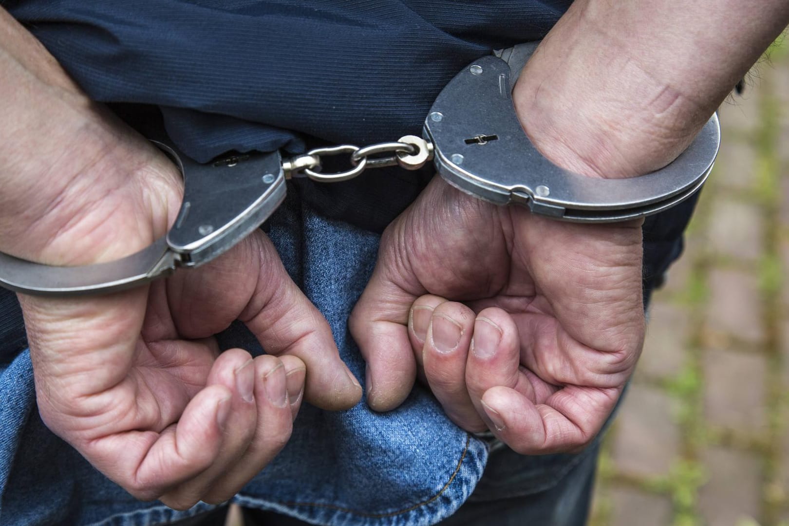 Ein Mann in Handschellen (Symbolbild): Ein 18-Jähriger soll in Hamburg mehrere Sexualdelikte begangen haben. Er wurde festgenommen.
