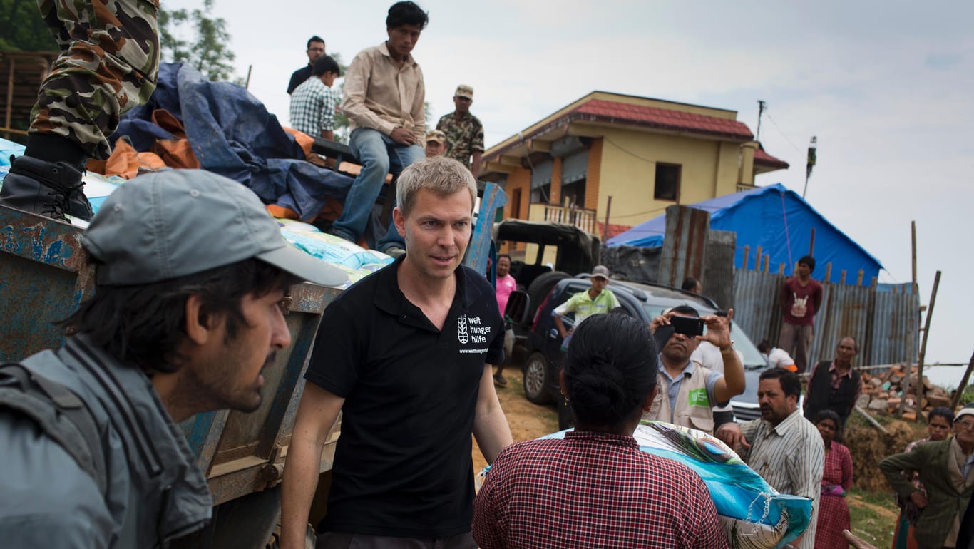 Welthungerhilfe-Chef Till Wahnbaeck (M.): Nahrungsmittelverteilung im Dorf Jhangajhiti im Kathmandu Valley, Nepal.