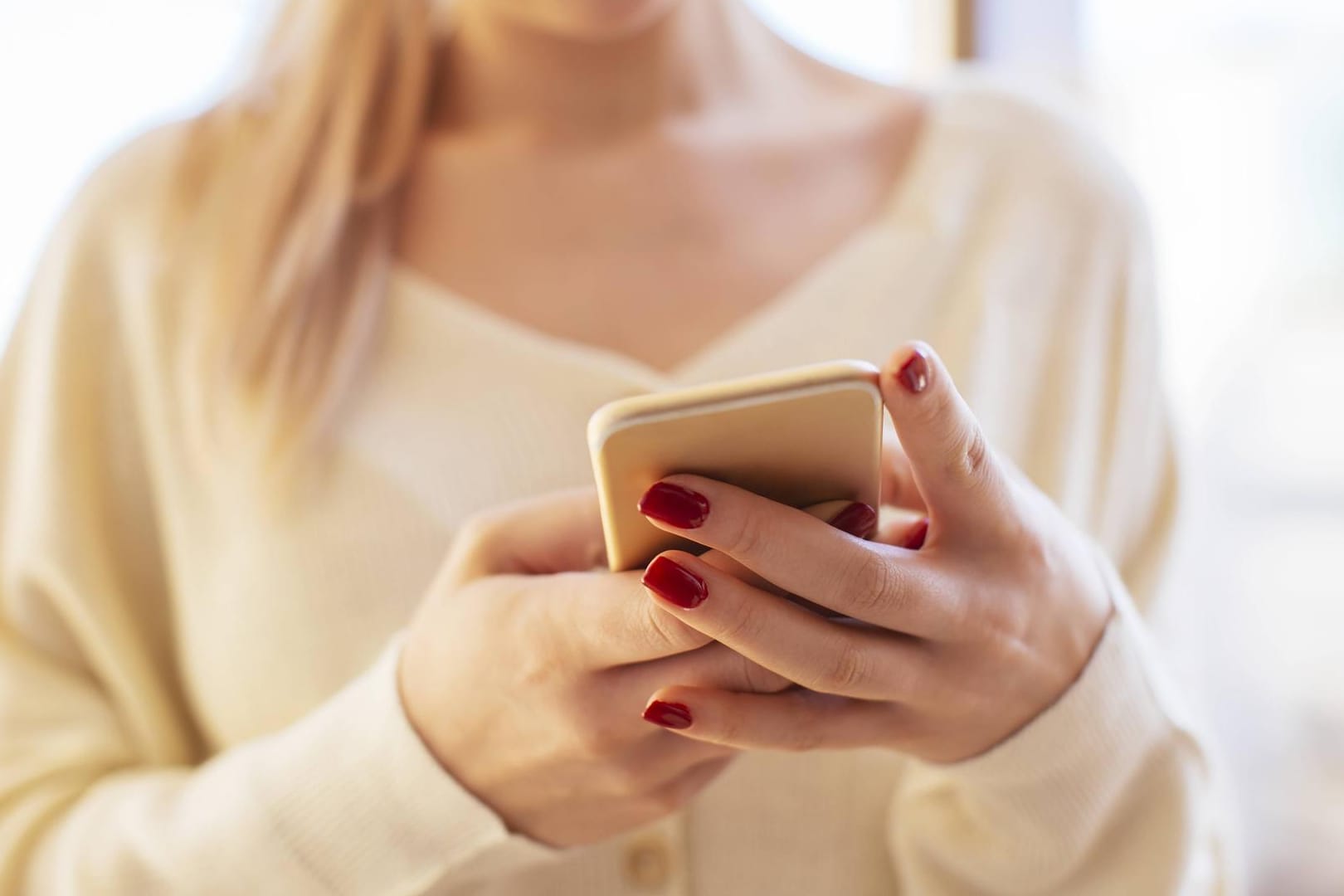 Junge Frau mit iPhone: Neue Akkuprobleme unter iOS 11.4 entdeckt.