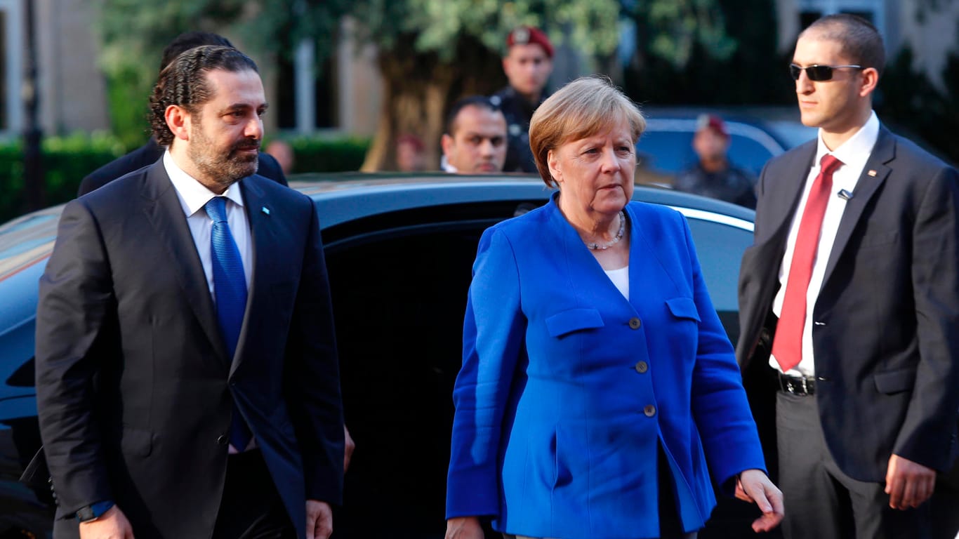Saad Hariri, Ministerpräsident des Libanon, holt Bundeskanzlerin Angela Merkel (CDU) zur Begrüßung an ihrem Wagen ab: Ihre Reise soll auch in stürmischen Zeiten nach politischer Normalität aussehen.