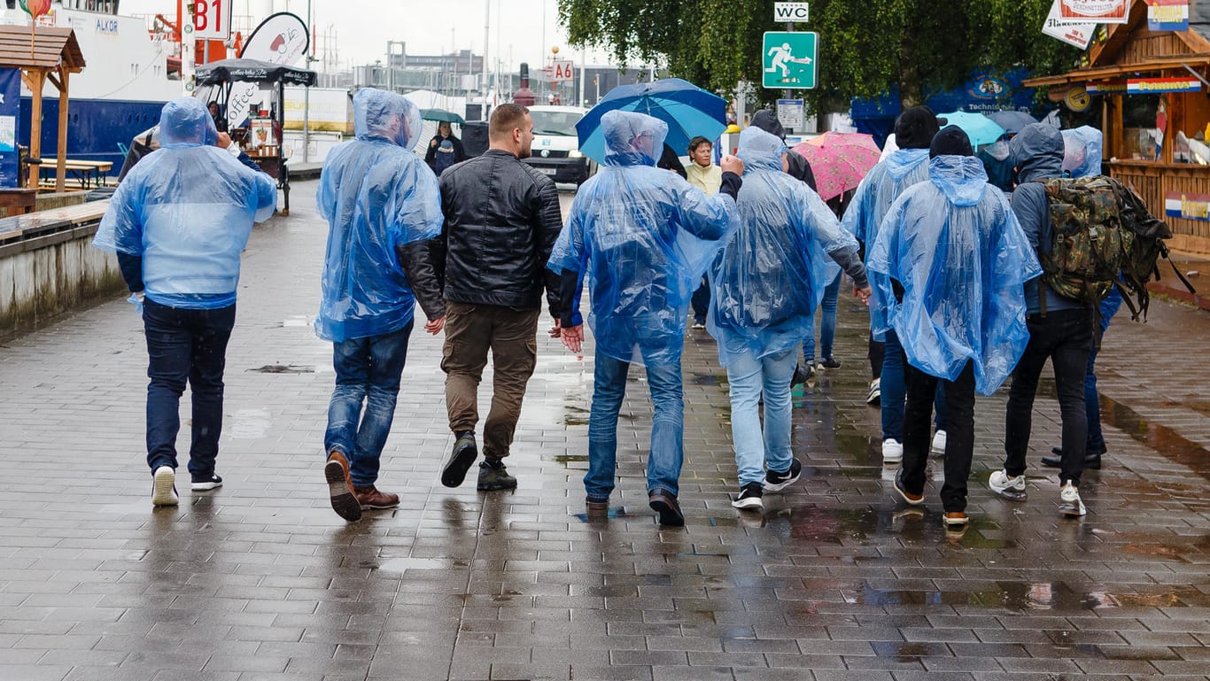 Besucher der Kieler Woche schützen sich mit Regenponchos vor einem Wolkenbruch: Ein kalter Tag zum kalendarischen Sommeranfang ist keine Seltenheit, erklärt unser Kolumnist Jörg Kachelmann.