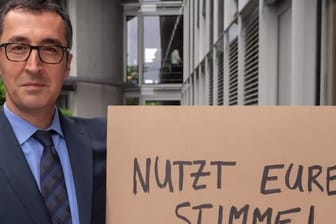 Cem Özdemir hält ein Schild mit den Worten "Nutzt eure Stimme!" in die Kamera: Auch andere Grünen-Politker wie Claudia Roth treten in dem Video auf.