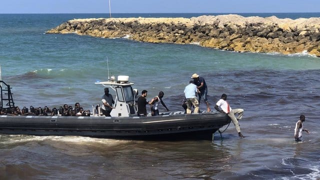 Eine Gruppe afrikanischer Migranten wird von der libyschen Küstenwache an Land gebracht. Eine Gruppe afrikanischer Migranten wird von der libyschen Küstenwache an Land gebracht.