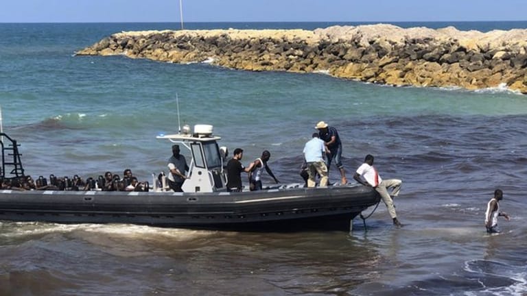 Eine Gruppe afrikanischer Migranten wird von der libyschen Küstenwache an Land gebracht.
