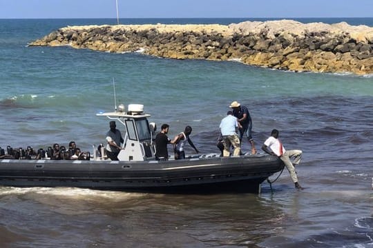 Eine Gruppe afrikanischer Migranten wird von der libyschen Küstenwache an Land gebracht.