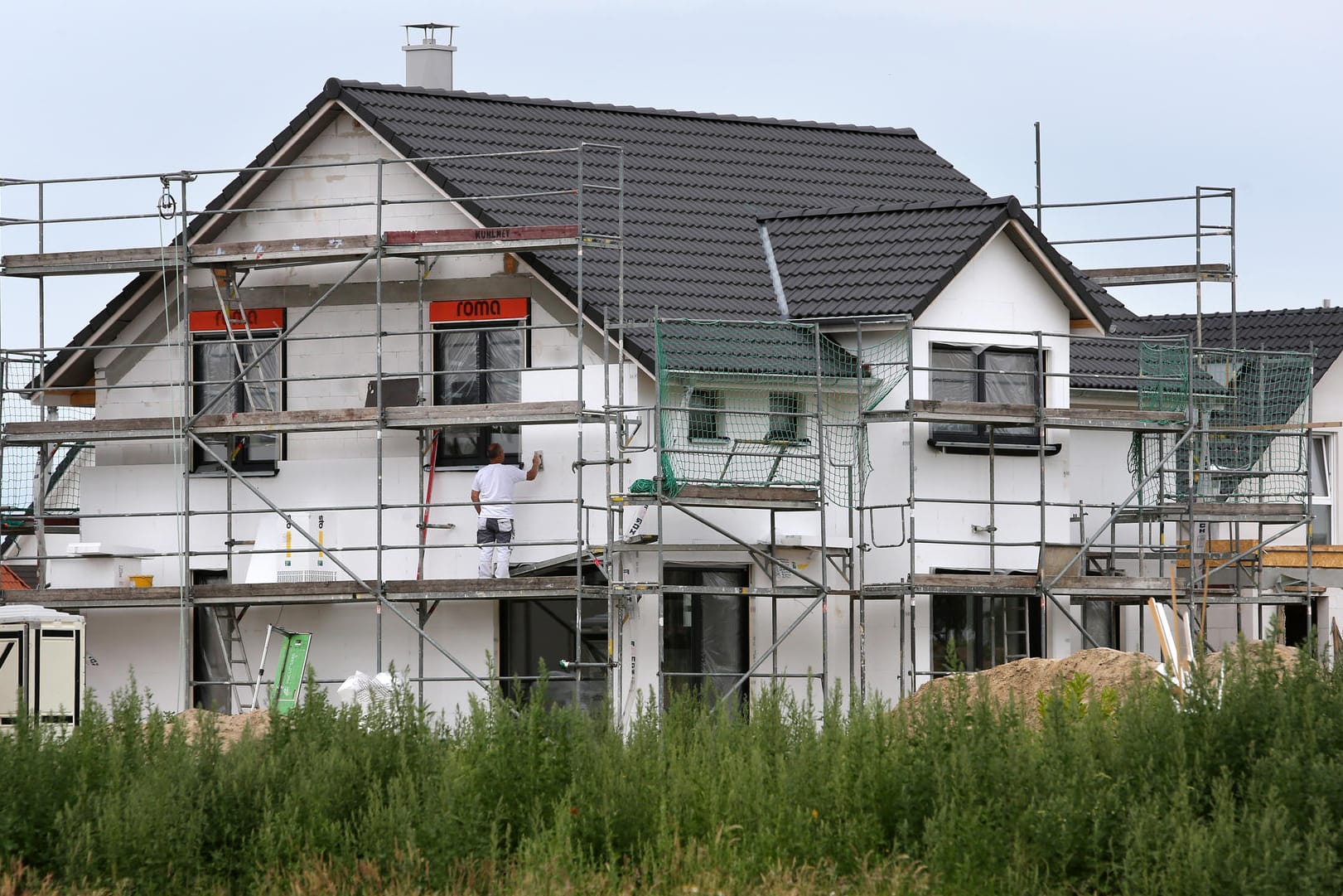 Bauarbeiter arbeiten an der Fertigstellung von Einfamilienhäusern: Für Familien mit mehr als zwei Kindern soll es 10 Quadratmeter mehr pro Kind geben. (Archivbild)