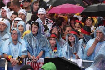 Fans auf der verregneten Berliner Fanmeile bei der WM 2014: Während des Spiels gegen Schweden kann es in Deutschland ähnlich schlechtes Wetter geben.